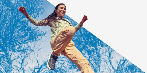 A woman hiking with a blue-filtered background.