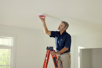 Installer removing the dust cover on a Kidde smart device.