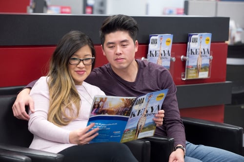 Members in waiting area browse travel magazine