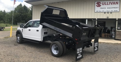 white dump truck in front of shop