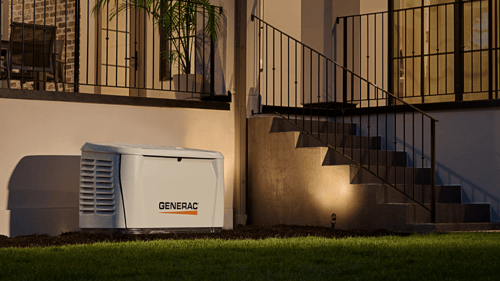 Generac home standby generator installed outside house at night