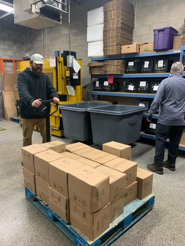 Warehouse crew staging boxed supplies for commercial exterior work.