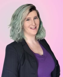 Owner Morgan Buck smiling for the camera in front of a pink backdrop