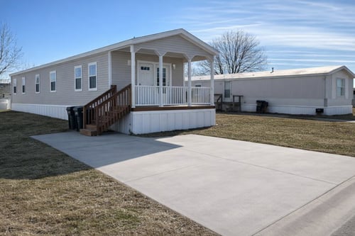 A mobile home with a porch and a covered patio.