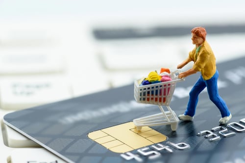 Man shopping on top of credit card