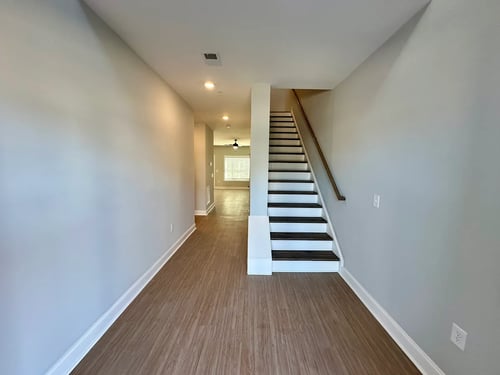 Hallway with staircase at Regency Townes in Greenville, NC