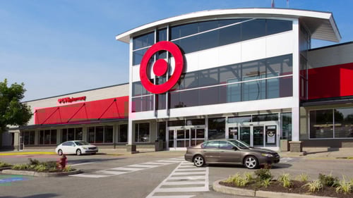 Beige car and white car driving in front of Target