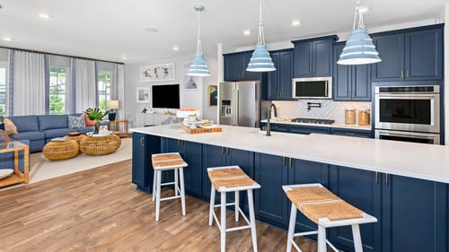Kitchen with blue cabinets, large island with 3 bar stools.