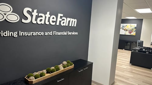 Gray and black walls in office with white State Farm sign on wall