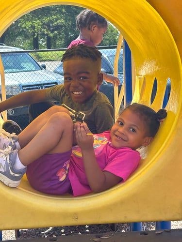 Kids crawling through a colorful tunnel on the playground, engaging in active and imaginative play.