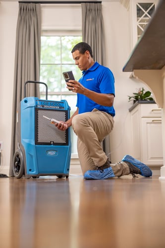 Restoration 1 tech setting up drying equipment.