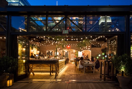 Refinery rooftop with string lights and bar