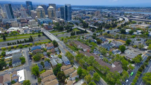 A cityscape with a mix of residential and commercial buildings at Oak Village Apartments, Oakland, CA