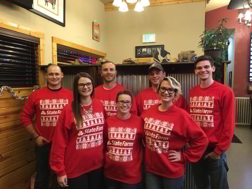 Al and six team members standing together in red Christmas sweaters