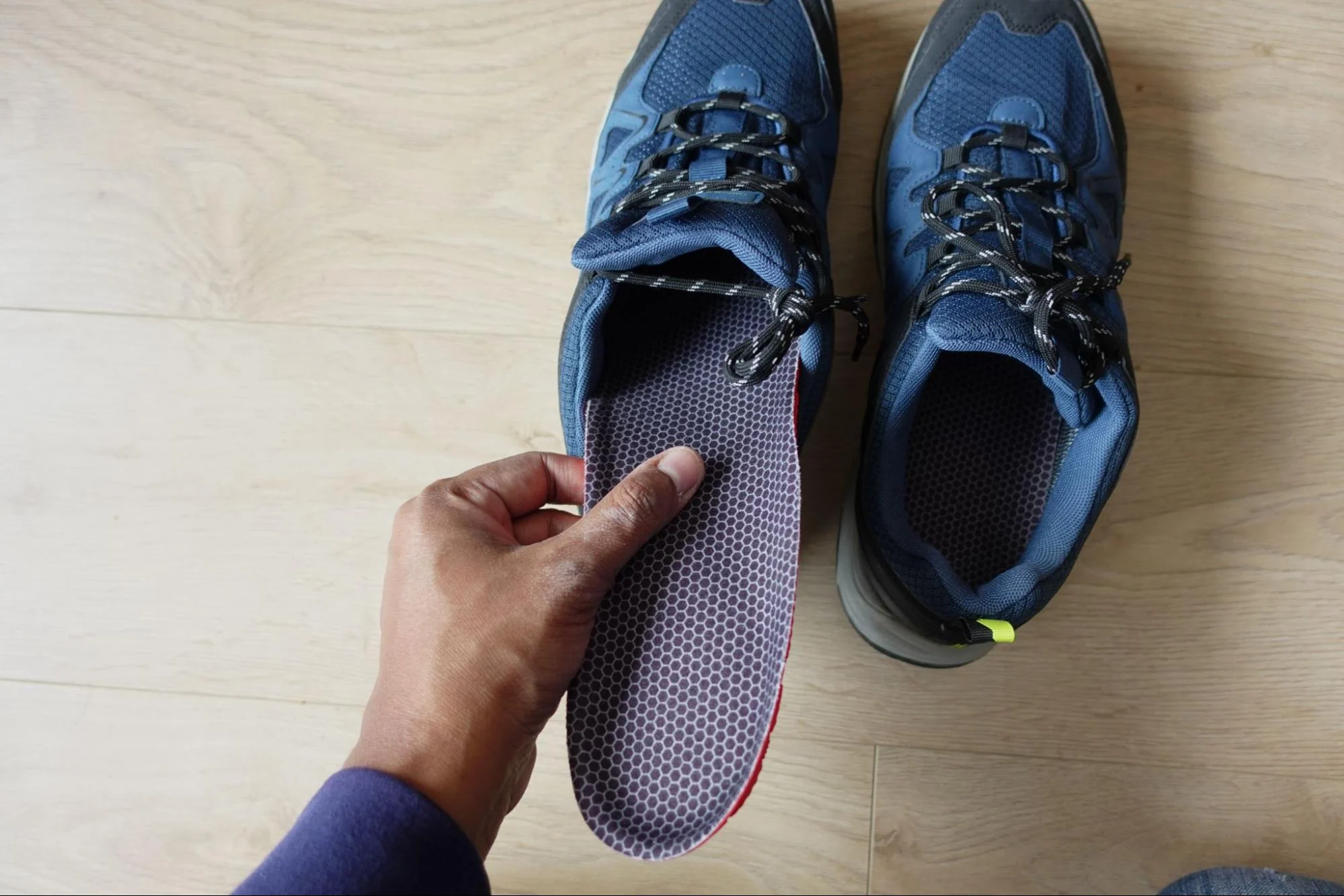 person putting insoles into shoes for arch support for flat feet