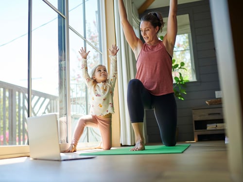 Mother and daughter doing yoga enjoying top internet plans in your area.