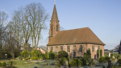 Das Kirchengebäude umringt von einem Friedhof.
