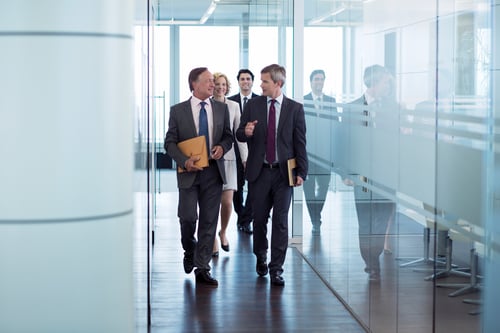 business people walking as a group in office setting