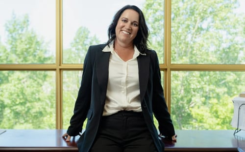 Picture of a brunette woman of Caucasian descent sitting on a chair.