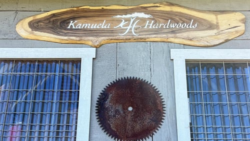 piece of wood hanging with company logo on it