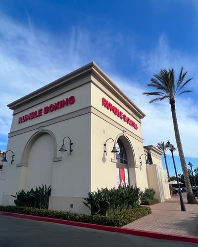 Storefront Building of Rumble Boxing fitness center and palm trees in Irvine California.