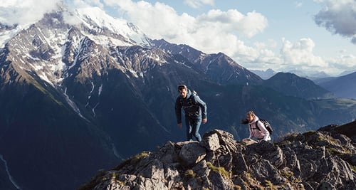 Homme et femme en randonnée dans les montagnes avec des vêtements d'extérieur Columbia.