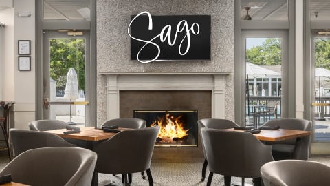 Interior of Sago restaurant with elegant coastal décor and patio views of the pool