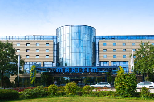 Außenansicht vom Maritim Hotel Bonn: Eine riesige Glasfassade mit großen Eingangsbereich und Parkanlage.