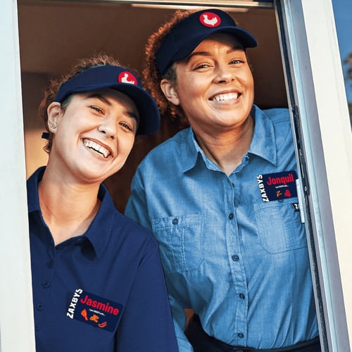 Smiling team members working at a drive thru window