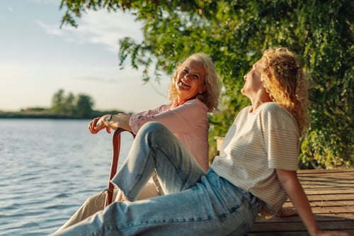 mother and daughter on a dock by a lake