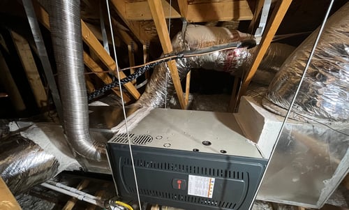 Regular maintenance on furnace unit in the attic