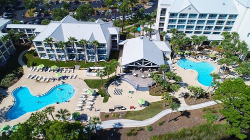 An aerial view of Bluegreen's Bayside Resort and Spa featuring our pool side bar, two outdoor pools, and ample pool deck lounge space.