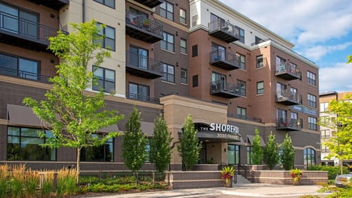 Modern apartment building entrance with balconies at The Shoreham Logo in St. Louis Park, Minnesota