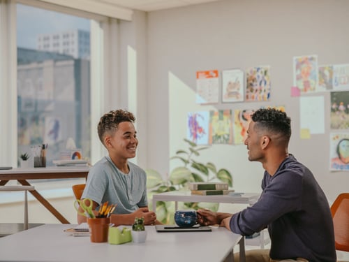 A student and a teacher talking in a Fusion Academy 1-to-1 classroom.