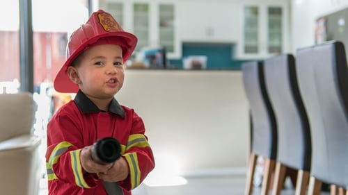A child dressed as a firefighter, symbolizing the importance of teaching fire safety to children.