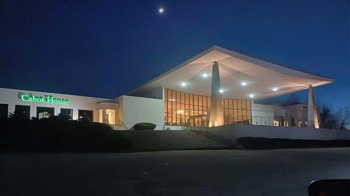 Storefront of Cabot House Furniture Framingham location at night showing a large lighted entryway and lit up sign.