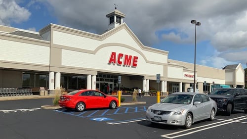 Red car and silver car parked in front of Acme at Unity Plaza shopping plaza