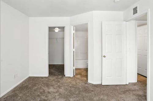 A room with a white door and a carpeted floor.at Country Oaks Apartments, Clearfield, 84015