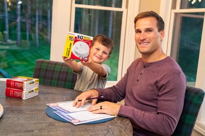 Kirk Cousins, quarterback, and his son at a kitchen table.