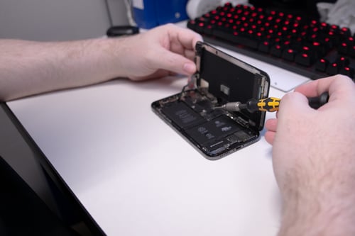 Certified technician making repairs to internal components of cell phone