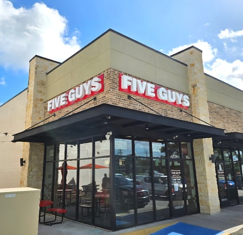 Exterior photograph of the Five Guys restaurant at 10463 TX-242 in Conroe, Texas.