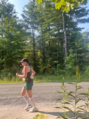 Image of Colleen Running on a sunny outdoor trail