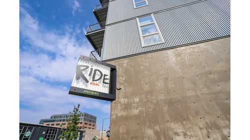 A building with a sign at RiDE at RiNo Apartments, Denver, CO, 80216