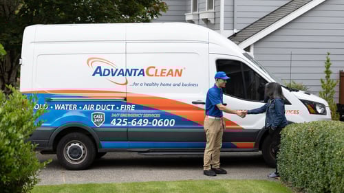 AdvantaClean van and tech shaking the hand of a homeowner