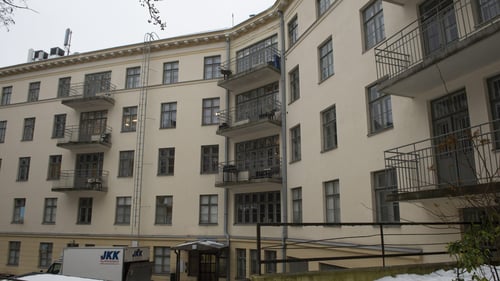 Ulkokuva Alppikorttelin Elim-rakennuksesta, jossa Lehmustupa sijaitsee. Rakennus on 5-kerroksinen ja siinä on parvekkeita. Seinäkivi on valtaosin vaalean sävyistä, mutta alin kerros on keltaisempaa sävyä. Maassa on lunta.