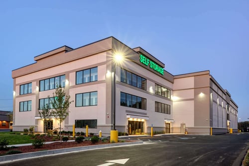 Exterior of Drum Hill Storage Solutions self-storage facility in Chelmsford, MA at dusk with facility signage.