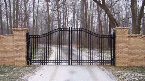 metal fence between brick pillars