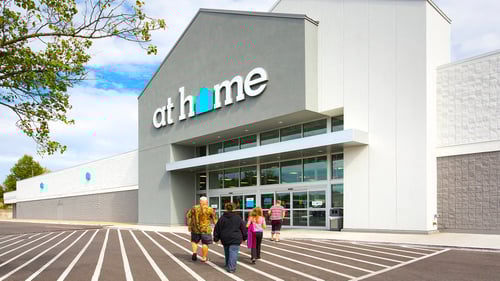 Four people walking into At Home with a tree hanging over on the left side