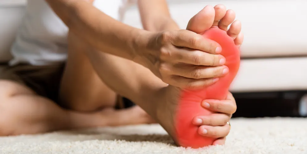 person grasping foot in pain