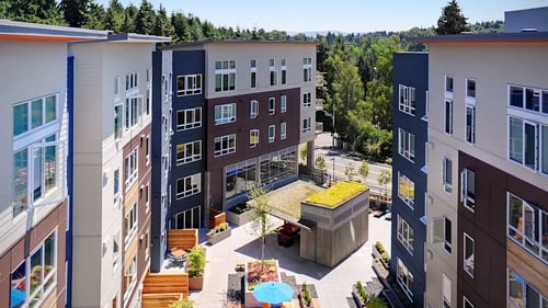 A view of a courtyard with a green roof and a pool surrounded by buildings at Kirkland Crossing, Washington